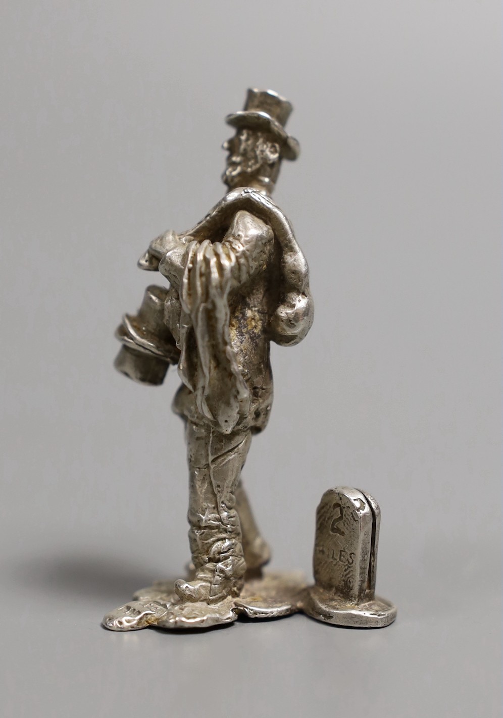 A modern novelty silver menu holder modelled as a traveller by a milestone, by Thomas Charles Jarvis, London, 1971, 57mm, 53 grams.